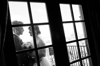 bride and groom behind glass door