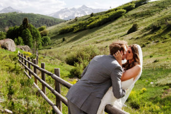 Telluride, Colorado Bride and groom kiss on a fence in Telluride, Colorado