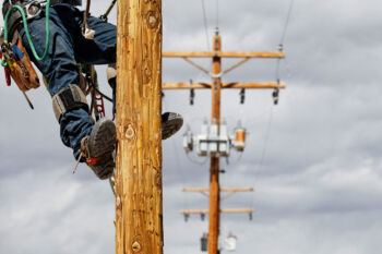 lineman's feet on a power pole