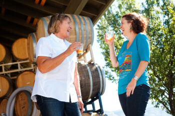 women laughing while drinking wine