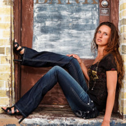 Halley Combs models clothing from The Wild Rose in Montrose, Colorado. model posing in a bank door way