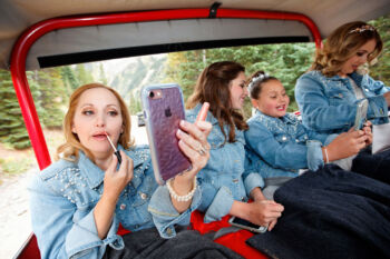 bridal party puts on makeup in a jeep